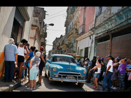 People wait in line to buy chicken at a government-run grocery store in Havana, Cuba, last Saturday. The Cuban government said last Friday that it will begin widespread rationing of chicken, eggs, rice, beans, soap and other basic products in the face of a grave economic crisis.