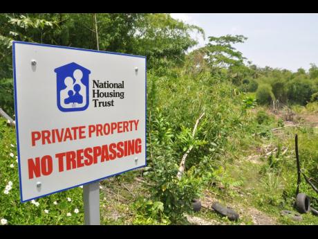 A sign shows a proposed development site for NHT houses. The state agency is still consulting on the design of an intergenerational mortgage programme that is supposed to make mortgages more accessible for Jamaicans.