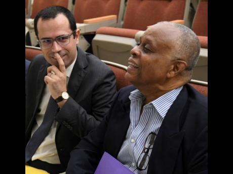 Dr Casimiro Dias (left), adviser on health systems and services at PAHO/WHO, looks at an animated Raphael Barrett, health management consultant, during the inaugural Health Information Management Conference at UTech on Thursday, May 16. 