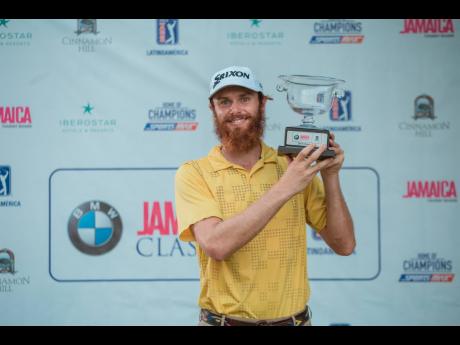 American Evan Harmeling poses with his BMW Jamaica Golf Classic trophy after victory at the Cinnamon Hill course in Montego Bay yesterday. 