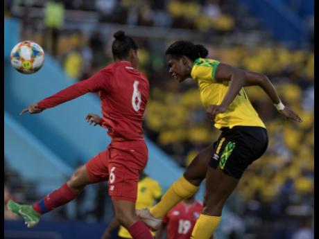 Jamaica’s Khadija Shaw (right) beats Panama’s Aldrith Quintero to a header during their international friendly match at the National Stadium in Kingston last night. 
