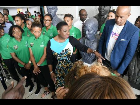 Sport Minister Olivia Grange (centre) and Caribbean Airlines director Zachary Harding (right) chat with members of Jamaica''s senior women''s football team at a farewell event hosted by sponsor Caribbean Airlines at the Norman Manley International Airport yesterday. 