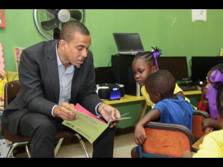 Rotary Club of New Kingston member Dr Peter Johnson reads to students at the Gordon Town Basic School in St Andrew.