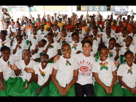 Zuriel Oduwole poses with Mona Heights Primary School students. The girls, most between ages nine and 12, enjoyed sharing their career goals, which ranged from becoming lawyers, doctors, and teachers to entrepreneurs, police officers, chefs, and astronauts. 