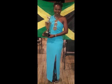 Faith Ellis displaying the trophy she won for being adjudged the Caribbean Champion of Public Speaking at the Toastmasters International District 81 Annual Conference in Bonaire, the Caribbean part of the Netherlands, recently.
