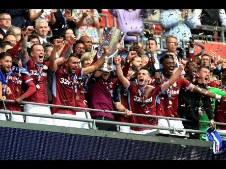 Aston Villa’s Jack Grealish (centre left) and James Chester (centre right) celebrate with the trophy after winning the English Championship Play-off final between Aston Villa and Derby County at Wembley Stadium, London, yesterday. 