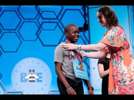 Eleven-year-old Jamaican speller Darian  Douglas of Glenmuir High School is awarded his medal after being named among the finalists in the 2019 Scripps National Spelling Bee yesterday. There are 565 spellers in this year’s competition, ranging in age from seven to 15. The finals will take place today.