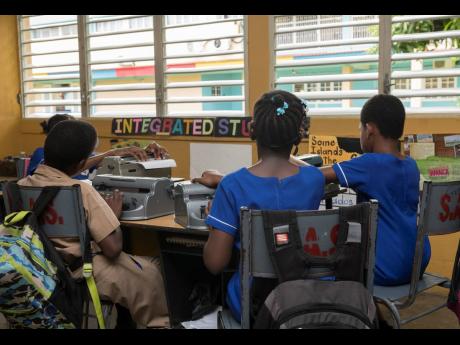 Students operate Perkins Braillers – a braille code typewriter – in a classroom at the Salvation Army School for the Blind on Mannings Hill Road in St Andrew last Friday.