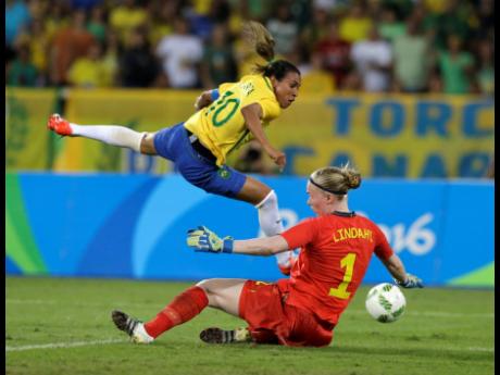 In this August 6, 2016, file photo, Brazil’s Marta (left) leaps over Sweden goalkeeper Hedvig Lindahl as she attempts a shot on goal during the Olympic football tournament in Rio De Janeiro, Brazil. 