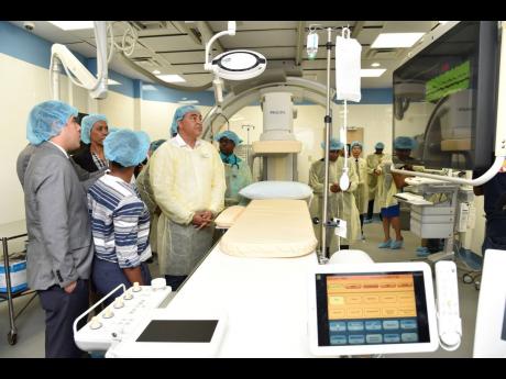 Minister of Health and Wellness Dr Christopher Tufton (right); and (from left) Asdrubal Mata, cluster leader, North Latam, Philips Colombiana SAS, Minister of Science, Energy and Technology Fayval Williams; and consultant cardiologist at the University Hospital of the West Indies (UHWI), Nordia Clare-Pascoe, view  equipment in the Interventional Suite at the UHWI, which was officially opened last week.