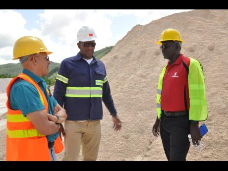 Eddie Cousins (left) director of Lydford Mining, and his operations director, Sam Millington (centre), talk with Daniel Brown, senior manager of the mid-market segment of Scotiabank’s corporate and commercial banking, at the site of their mining operations in St Ann. The company became the first exporter of crushed limestone sand to the United States when it shipped 4,800 tons of construction-grade limestone sand to the USVI in 2018. 