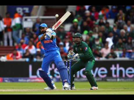India captain Virat Kohli plays a shot under the watch of Pakistan wicketkeeper-captain Sarfaraz Ahmed during their ICC World Cup match at Old Trafford in Manchester, England, yesterday. 
