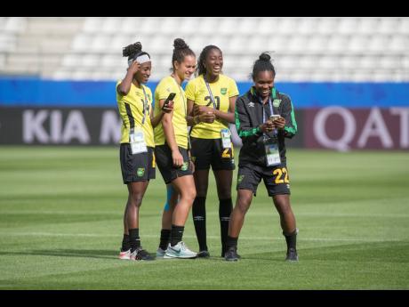 National senior women’s football team player Kayla McCoy (second left) shares a joke with teammates (from left) Deneisha Blackwood, Olufolasade Adamolekun and Mireya Grey during a familiarisation tour of the Stade Auguste-Delaune in Reims, France, last Thursday ahead of the team’s second FIFA Women’s World Cup match against Italy. 