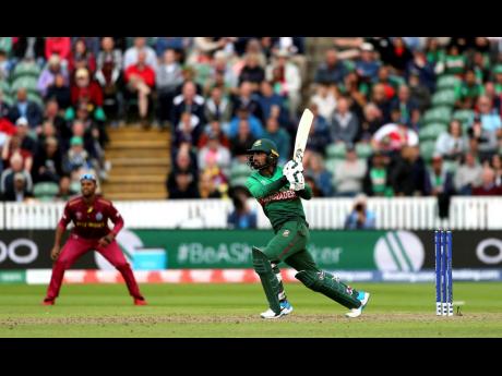 Bangladesh’s Liton Das smashes a shot for four runs during their ICC World Cup match with the Windies at The Taunton County Ground, Taunton, southwest England, yesterday. 