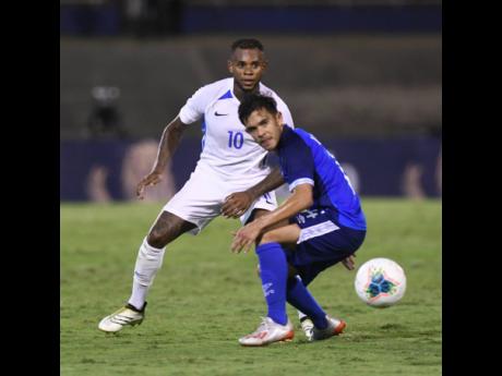 Curaçao Leandro Bacuna (right) plays the ball away from El Salvador’s Andres Flores in their Concacaf Gold Cup match at the National Stadium last night. 