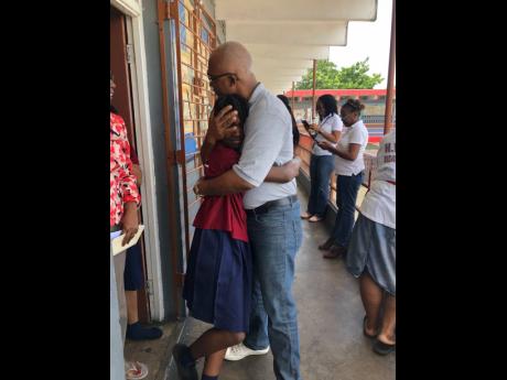 Kirah Malcolm is congratulated by her dad, Howard Malcolm, on hearing news that she had passed for Holy Childhood High.