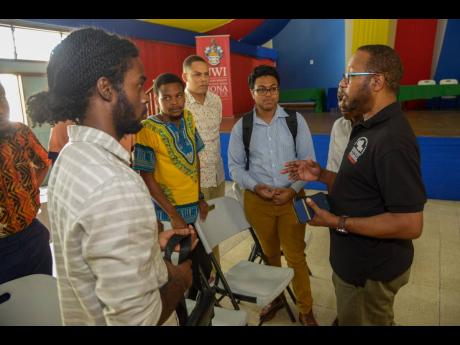 Ian Boxill, founder of GATFFEST (right), speaks with young film-makers and participants following  GATFFEST’s Film Pitch competition at The UWI, Mona, on Saturday.
