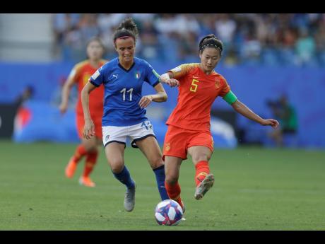 China's Wu Haiyan (right) tussles for the ball with Italy's Barbara Bonansea during the Women's World Cup round of 16 match between Italy and China at Stade de la Mosson in Montpellier, France, yesterday. Italy won 2-0. 