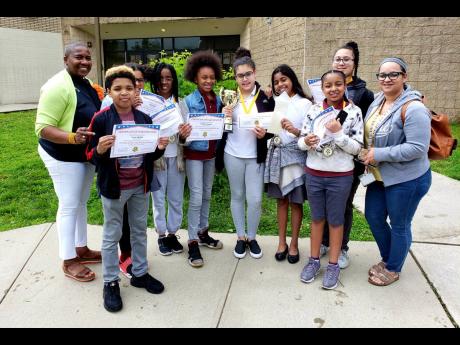 Students of Johnnie L. Cochran Junior Academy in East Orange, New Jersey, who won the inaugural Schools’ Challenge Quiz Bowl USA  competition, with Narda Morant (left), event founder and director, and Adalgisa Sosa (right), teacher and quiz coach at the school.