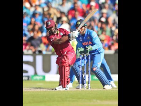 Windies’ Kemar Roach plays a shot during the ICC World Cup match against India at Old Trafford in Manchester, England, yesterday. 