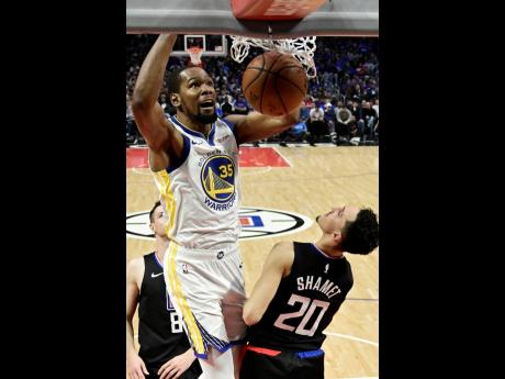 Golden State Warriors forward Kevin Durant (top) dunks as Los Angeles Clippers guard Landry Shamet defends during the second half of Game 4 of a first-round NBA play-off series in Los Angeles, California, on Sunday, April 21. 