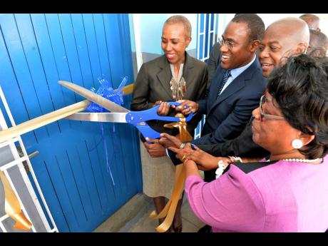 From left: Minister of Science, Energy and Technology Fayval Williams; Minister of Finance and the Public Service Dr Nigel Clarke; Chief Executive Officer of the Universal Service Fund (USF), Daniel Dawes; and principal of Maverley Primary and Junior High School Dorothy Taylor cut the ribbon to officially open a new computer lab/access point at the school earlier this year. The new lab was funded by the USF. 