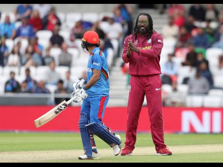 West Indies’ (WI) Chris Gayle (right) celebrates the dismissal of Afghanistan’s Ikram Ali during the Cricket World Cup match between Afghanistan and West Indies at Headingley in Leeds yesterday. The WI won by 23 runs.