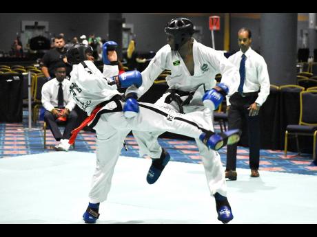 Nicholas Dusard (left) and fellow Jamaica combined martial arts teammate, Adrian Moore, clash in a feisty middleweight (-70kg) semi-final match of the International Taekwondo Associations  (International Taekwondo Federation) US Open Challenge Championships at the Coronado Springs Resort in Orlando, Florida, yesterday. Dusard won the bout and the division.