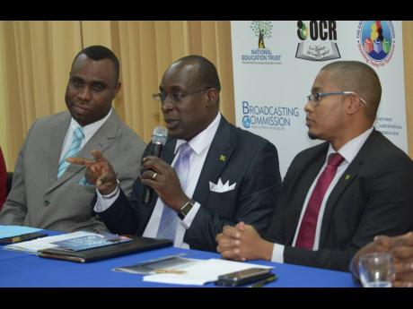 Then Minister of Education Senator Ruel Reid addresses a press conference in this February 2017 Gleaner file photo. At left is then Permanent Secretary Dean-Roy Bernard and at right is then State Minister Floyd Green.