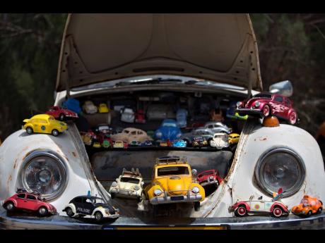 In this April 21, 2017 file photo, a collection of VW Beetle toy cars seen on a Volkswagen Beetle displayed during the annual gathering of the ‘Beetle Club’ in Yakum, central Israel. 