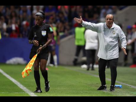 Jamaican assistant referee Princess Brown (left) moves about her touchline as Brazil head coach Vadao gives directions to his players during the FIFA Women’s World Cup round-of-16 match between France and Brazil at the Oceane Stadium in Le Havre, France, on Sunday, June 23. 