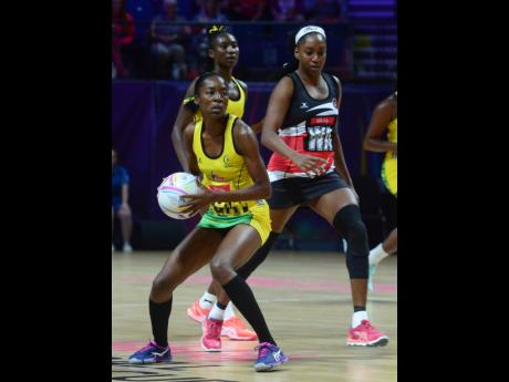 
Jamaica’s Shanice Beckford (left) gets the attention of Trinidad and Tobago’s Rhonda John-Davis during their Netball World Cup match at the M&S Bank Arena in Liverpool, England, yesterday. The Jamaicans won 68-43 and will face South Africa today at 11:00 a.m.