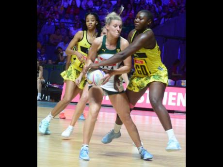 South Africa's Maryka Holtzhausen (centre) is challenged by Jamaica defenders Vangelee Williams (right) and Shamera Sterling during their Vitality Netball World Cup game at the M&S Bank Arena in Liverpool England this morning. Photo courtesy of Collin Reid, Courts Jamaica, Jamaica Tourist Board, Alliance Investments, Dairy Industries, and Supreme Ventures.