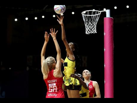 England's Helen Housby (left) and Jamaica's Shamera Sterling (top) battle for the ball during their Vitality Netball World Cup match in Liverpool, England this morning. (Nigel French/PA via AP)