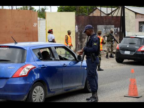 Members of the Jamaica Defence Force and the Jamaica Constabulary Force (JCF) conducting operations at a checkpoint along Waltham Park Road in the St Andrew South Police Division last Wednesday. The security measure, which was last week declared for an initial period of 14 days, has been extended until September.