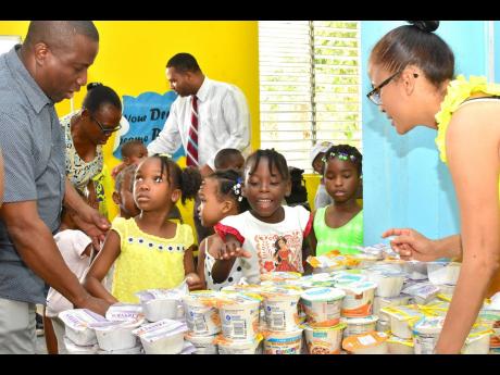 Keith ‘Chappy’ Taylor and his sister-in-law Racquel Taylor asks these children at the Woodford Seventh-day Adventist Preparatory School to select a snack from the table that they would like to have. 