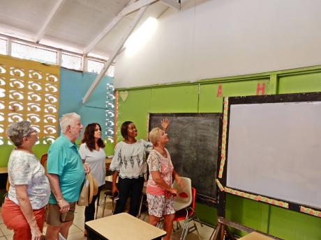 Principal Slean Harris (second right) shows the area where repairs were done to a classroom at Three Hills Primary School in Charles Town, St Mary. Others in the photo are (from left) Jane Saks, Gene Saks, Alex Ghisays and Darcy Fangman.