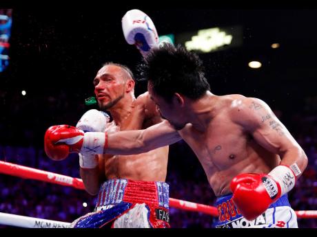 Manny Pacquiao (right), with a devastating right hook, punches the guard from Keith Thurman’s mouth during the fifth round of their World Boxing Association Welterweight title fight at the MGM Grand Garden in Las Vegas, Nevada, on Saturday. AP
