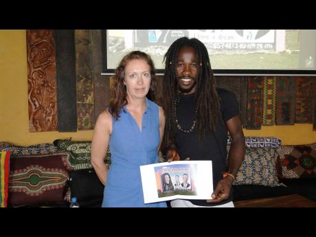 United Kingston mural specialist Tracey Thorne (left) with one of the Jamaican artists, Katapul, whose works she has photographed for her documentary photography project called ‘Hand-painted Jamaica’.