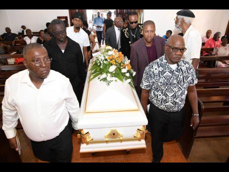 Pall-bearers carry the casket at the thanksgiving service for late Gleaner journalist Marc Stamp at the Dovecot Chapel, Dovecot Memorial Park, in Spanish Town, St Catherine, yesterday. 