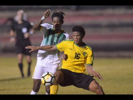 Jamaica’s Nicque Daley (right) shields the ball from Dominican defender Jolly Fitz during their Olympic Games qualifier at the Anthony Spaulding Sports Complex in Kingston, Jamaica, on Wednesday, July 17. The game ended 1-1. 