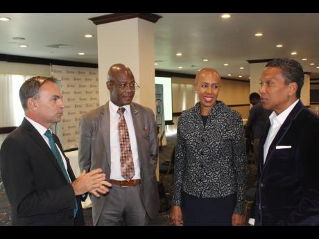 Minister of Science, Energy and Technology Fayval Williams (second right) chats with Daniel Dawes (second left), chief executive officer (CEO) at the Universal Service Fund; Colonel Martin Rickman (left), national coordinator of the HOPE Programme; and Chris Dehring, CEO of ReadyTV, before the launch of the USF’s Technology Advancement Programme at The Jamaica Pegasus hotel on Tuesday. 