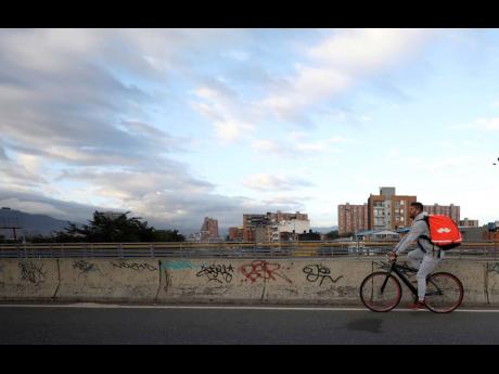 Venezuelan bicycle courier Samuel Romero pedals through Bogota, Colombia, at the start of his work day on Wednesday, July 17.