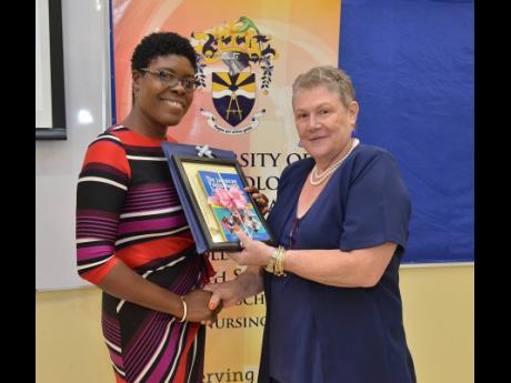 Dr Adella Campbell (left), head of the Caribbean School of Nursing at the University of Technology Jamaica, presents a book and a plaque to Dr Denise Eldemire-Shearer, senior lecturer in the Department of Community Health and Psychiatry, during the Fourth Annual Biennial Nursing Conference held at UTech's St Andrew campus yesterday.
