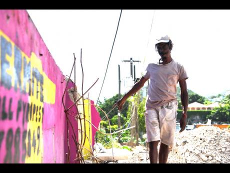 Lloyd Livingston walks on the rubble at the spot he had his shoemaking business in Manor Park, St Andrew. His shop was bulldozed to make way for the Constant Spring Road expansion project.