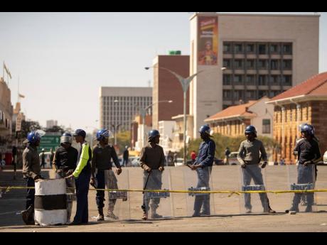 Police man a roadblock in Bulawayo, Zimbabwe, yesterday. Few people turned up for an opposition protest Monday in Zimbabwe’s second city as armed police maintained a heavy presence on the streets. 