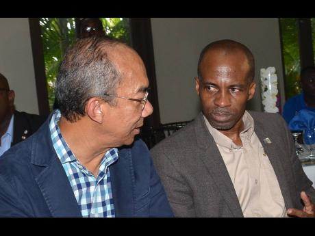 Minister of National Security Dr Horace Chang (left) in discussion with President of the Jamaica Chamber of Commerce  Lloyd Distant, at the Jamaica All-Island Chambers of Commerce quarterly luncheon in Clarendon on August 17.  Dr Chang was the guest speaker.