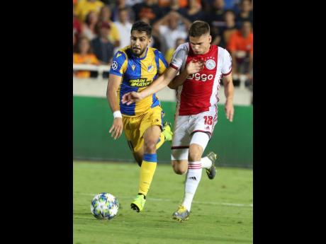 Ajax’s Razvan Marin (right) challenges for the ball with APOEL’s Musa Suleiman during their teams’ Champions League qualifying play-off first-leg match at GSP stadium in Nicosia, Cyprus, yesterday.