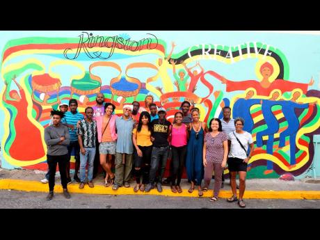 Artists in front of the augmented-reality mural in Kingston. 