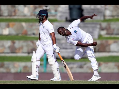 West Indies pace bowler Kemar Roach (right) bowls against India during day one of the first Test match at the Sir Vivian Richards Cricket Ground in North Sound, Antigua and Barbuda, yesterday. 